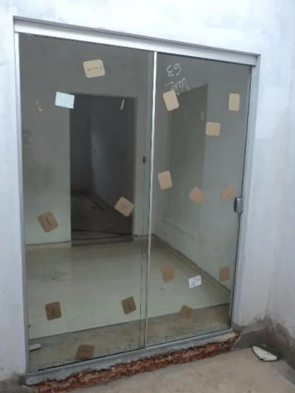 Porta de vidro de correr instalada em divisão de ambientes moderno