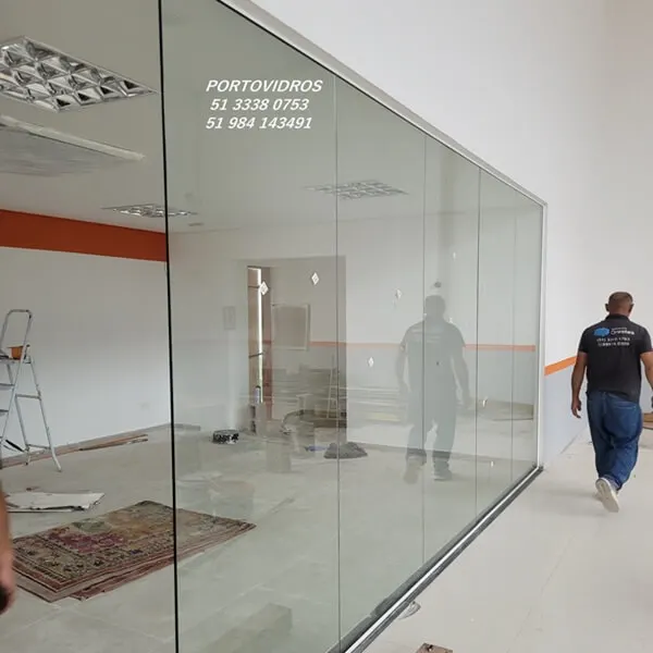 Divisória de vidro temperado instalada em escritório empresarial em Porto Alegre com acabamento moderno